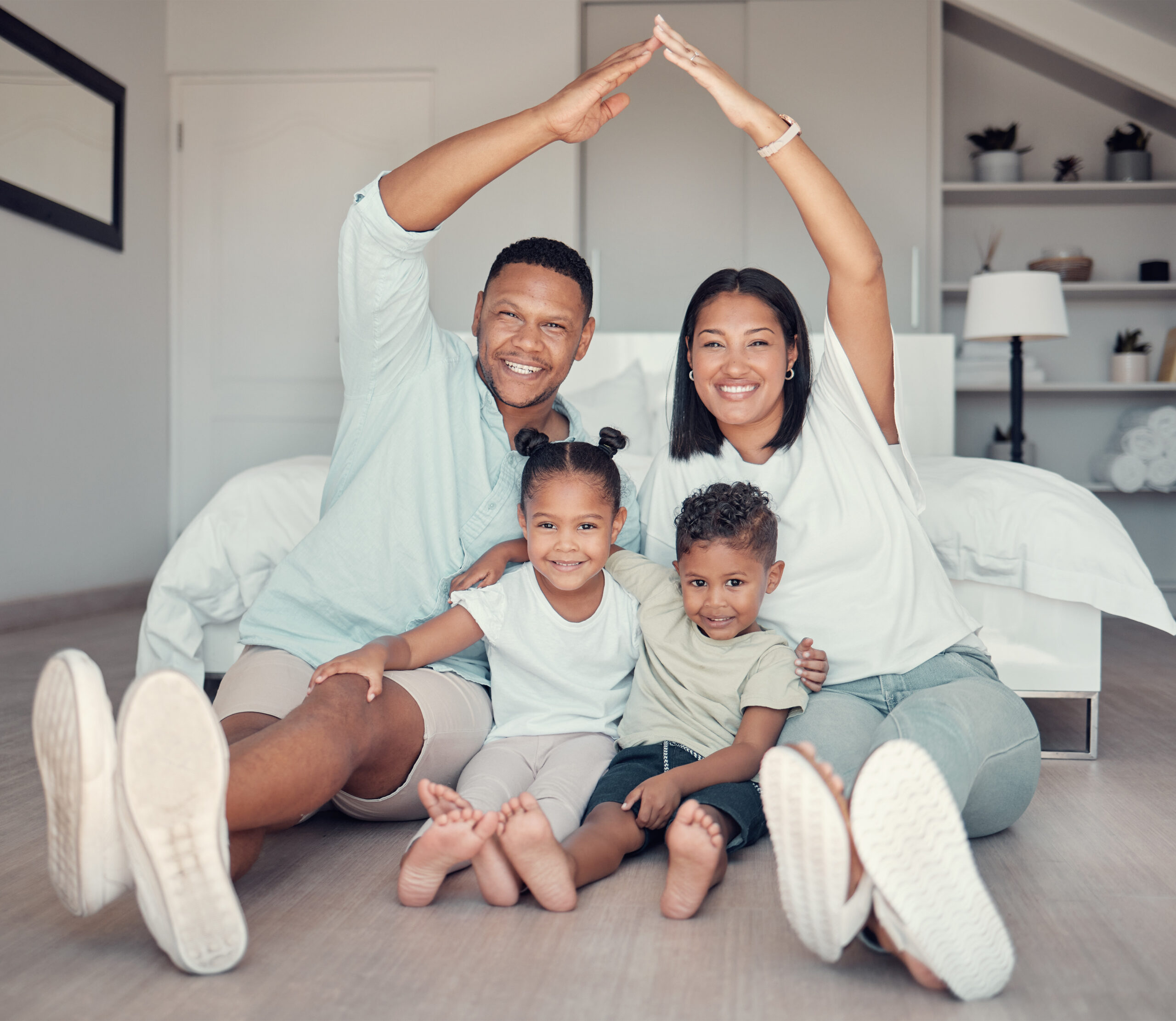 Family, roof and hands together for portrait on bedroom floor for insurance, support bonding and quality time. Security, protection and happy parents with children for love or safety in family home.